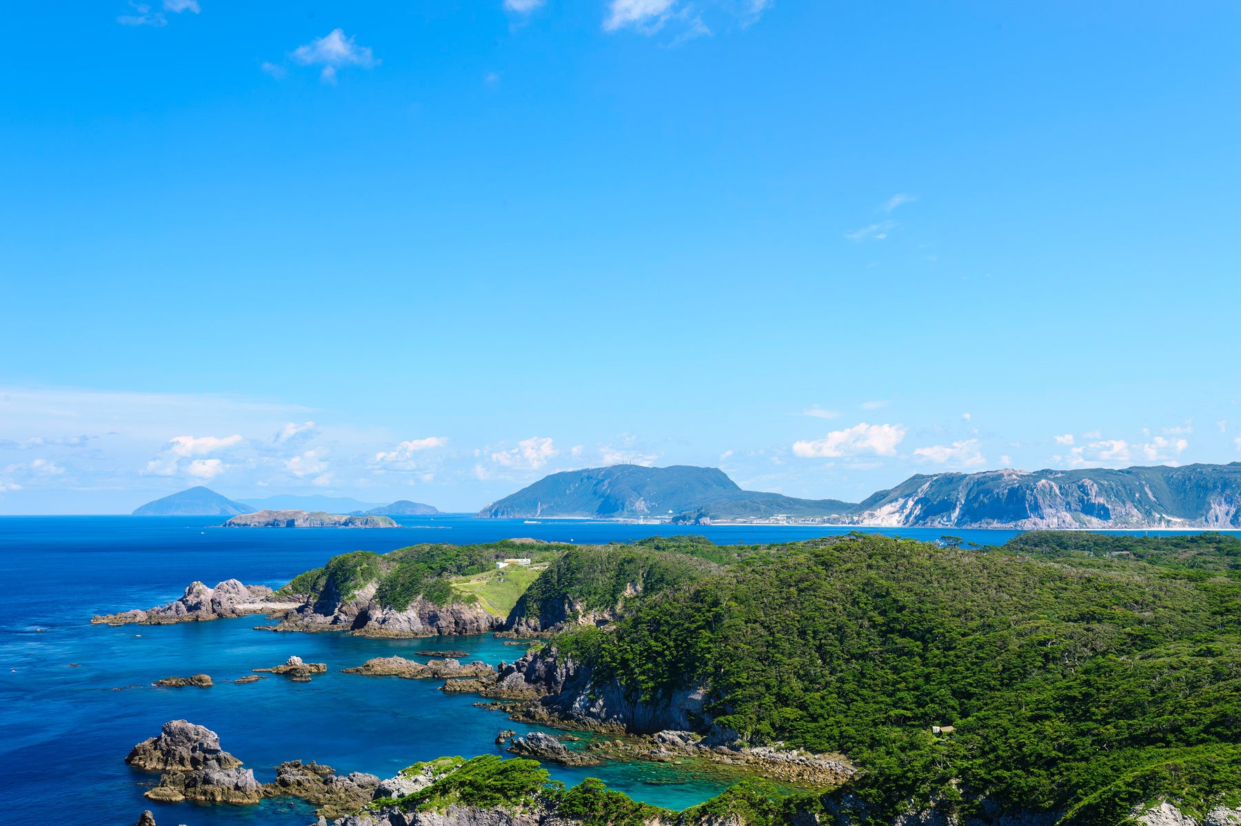 島の海岸線と山なみを望む風景