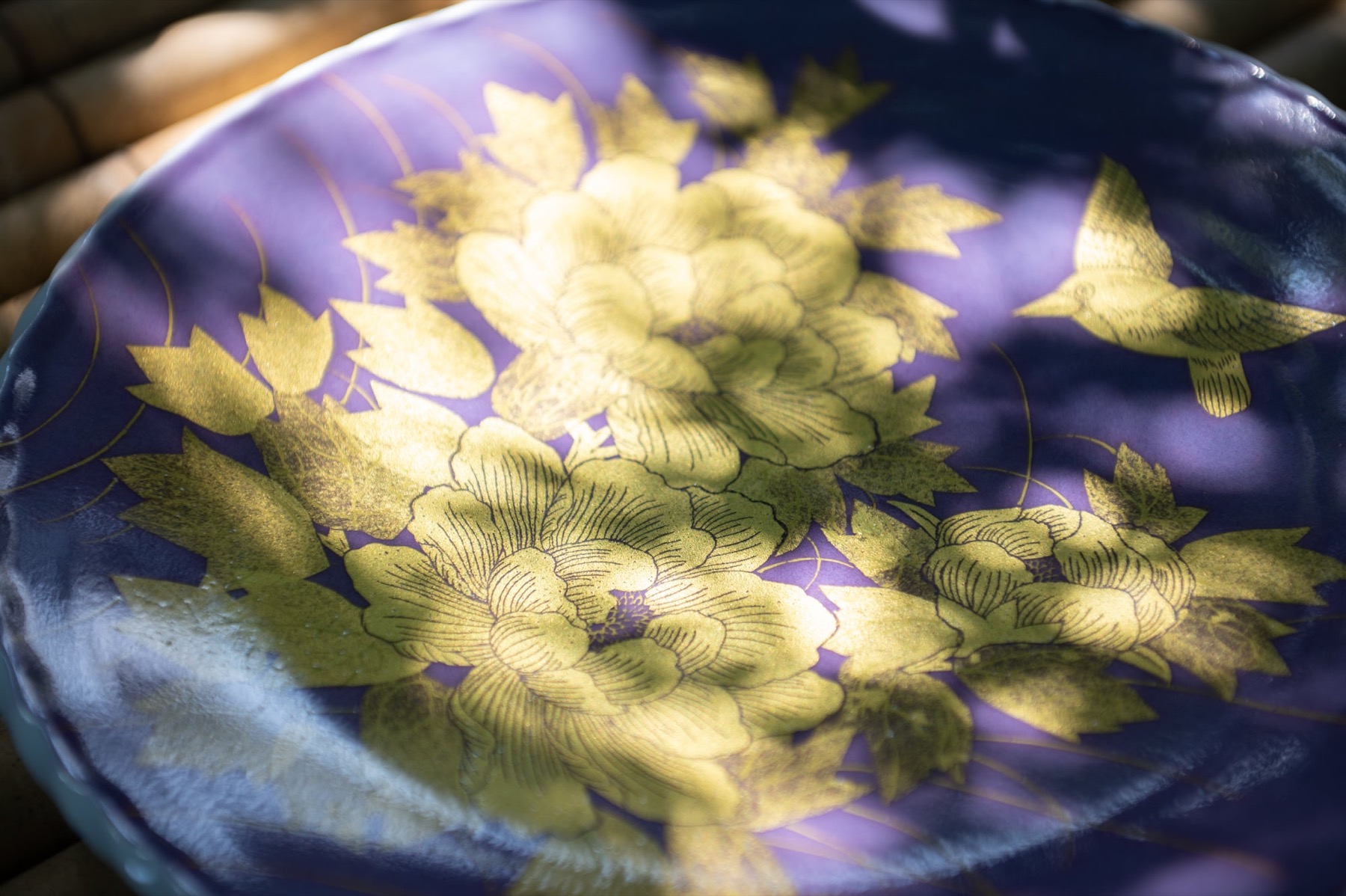 紫地に金の牡丹と鳥が描かれた皿